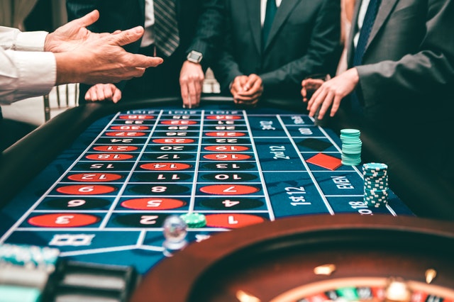 men gathered around a roulett table